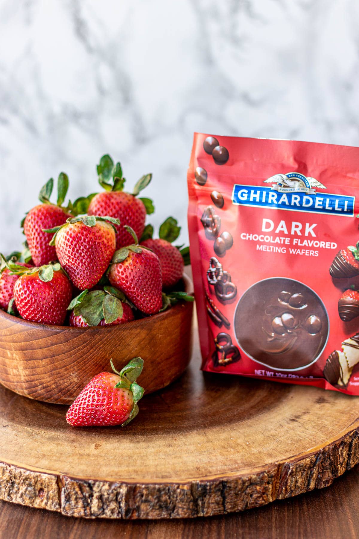 Strawberries in a bowl and melting chocolate in a bag