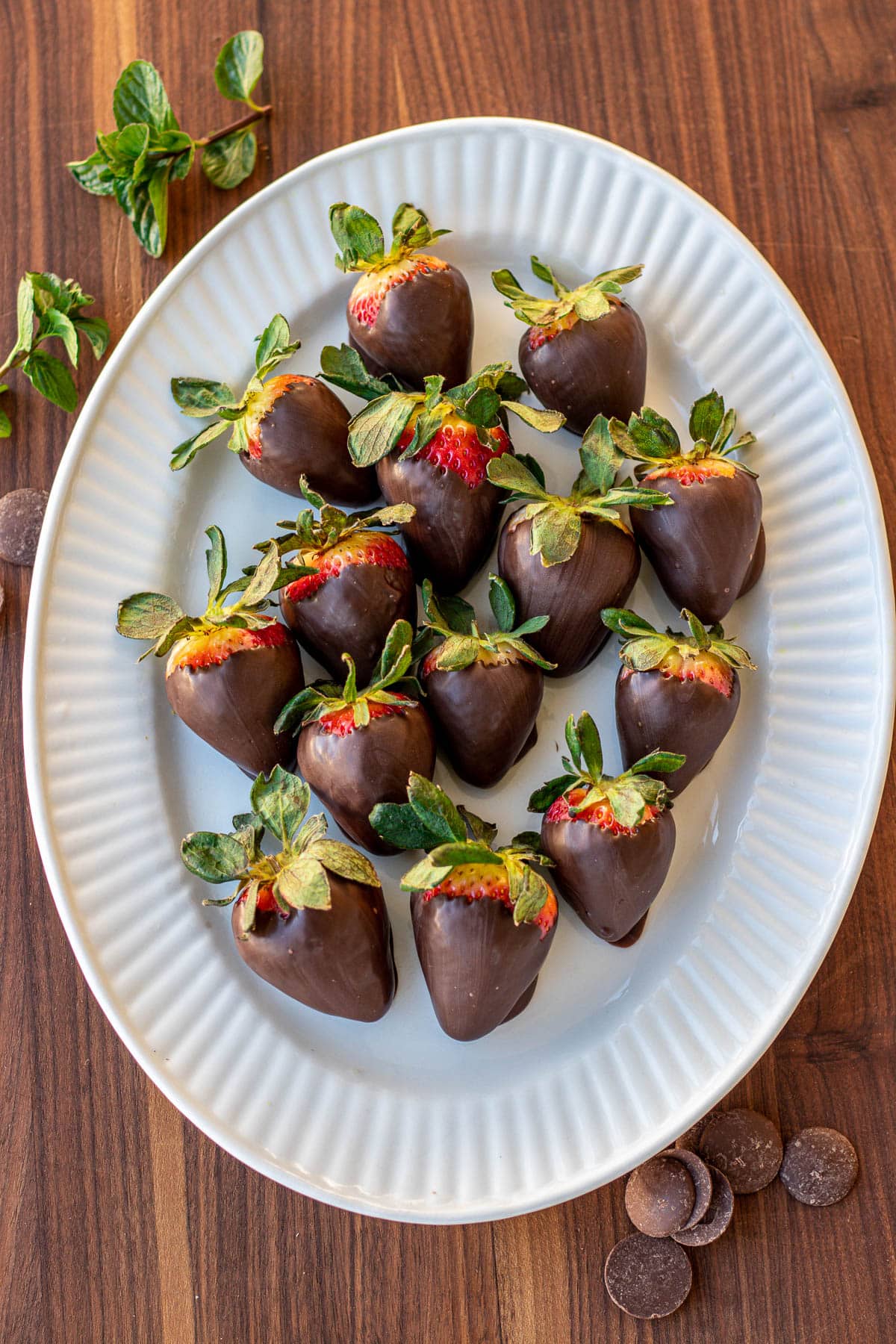 Strawberries covered in chocolate on a serving platter