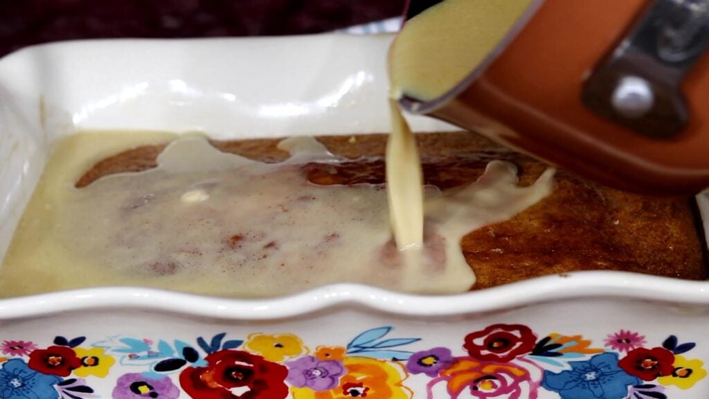 pouring butter sauce from saucepan onto cake