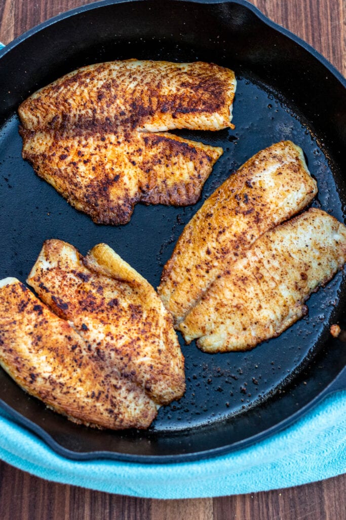 Tilapia fillets cooked in a cast iron pan