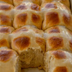 Hot Cross Buns in a baking dish with one removed