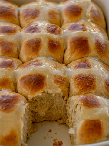 Hot Cross Buns in a baking dish with one removed