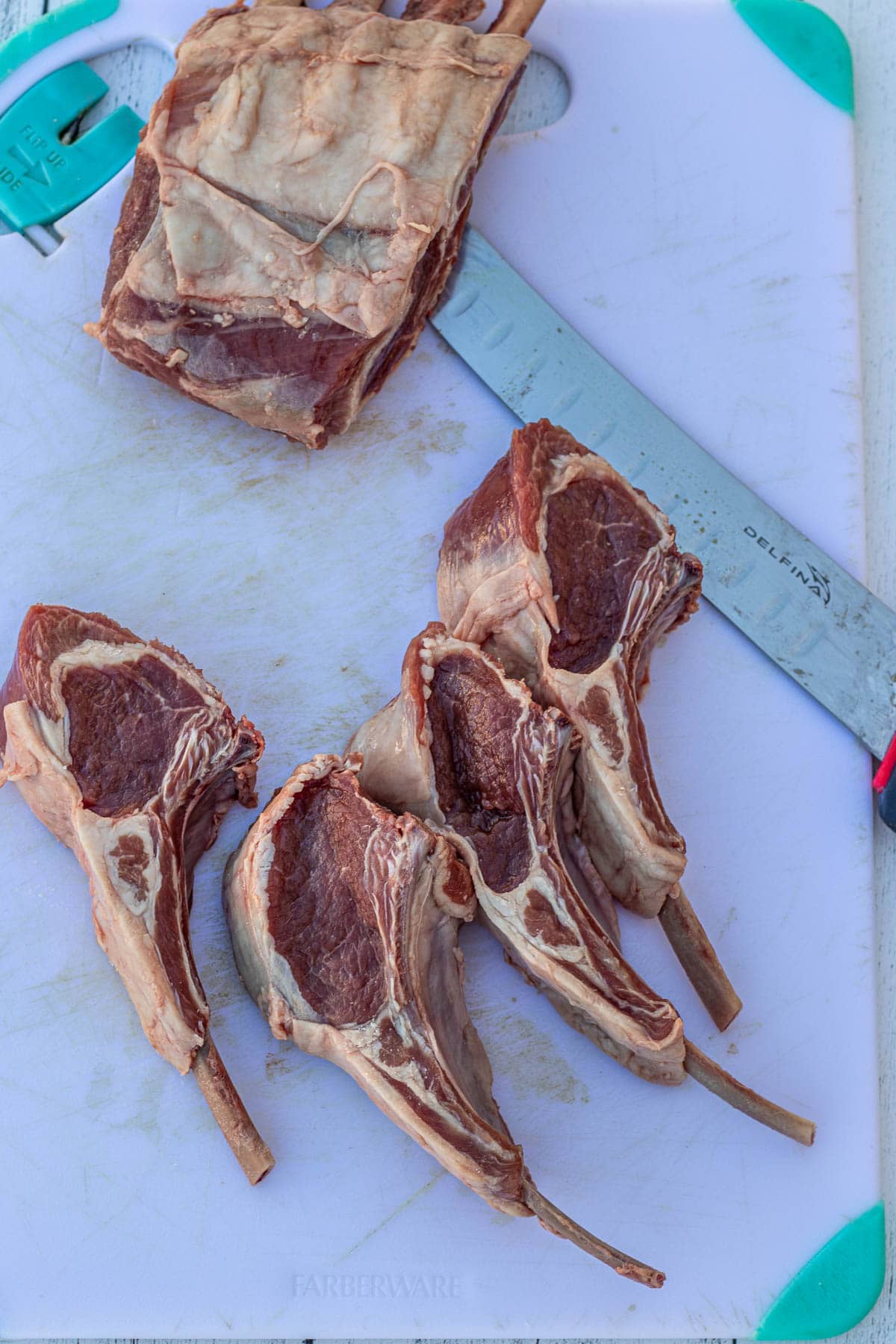 Cutting lamb chops on a chopping board.