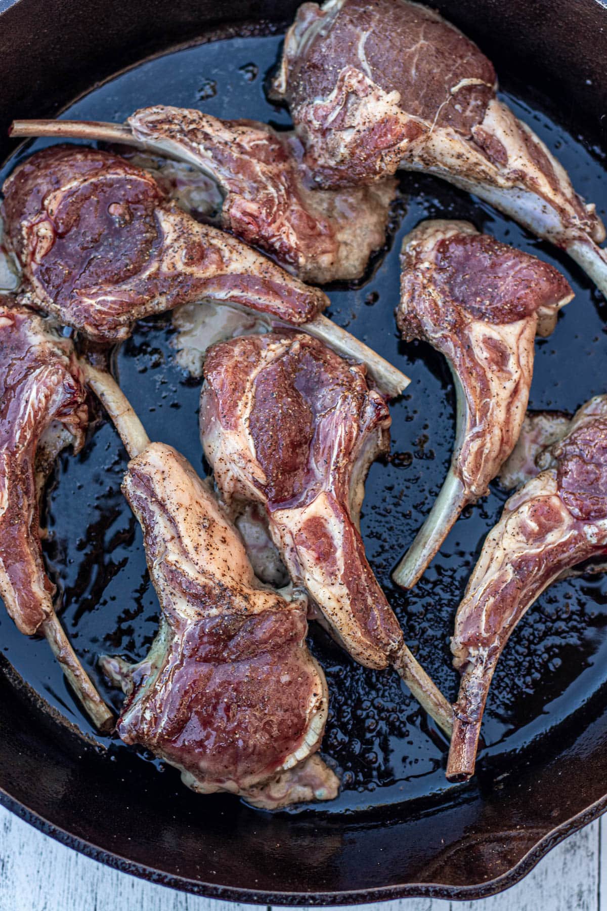 Lamb chops added to hot cast iron skillet.