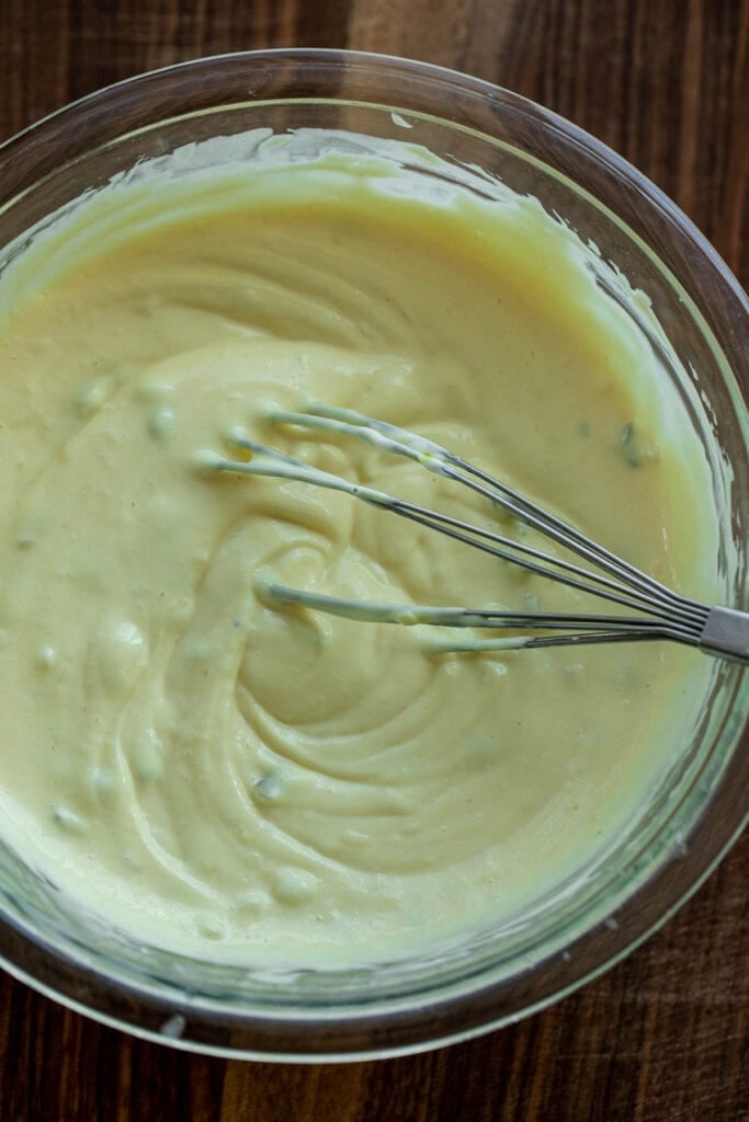 Creamy dressing with a whisk in a bowl