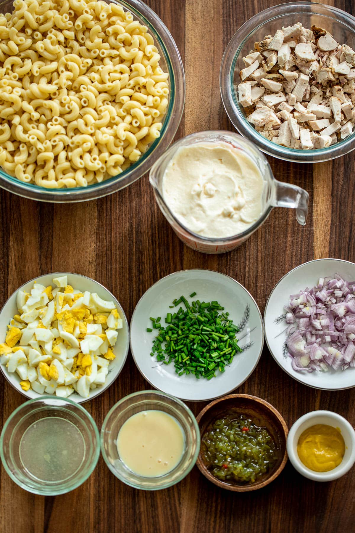 Ingredients for macaroni salad laid out on a chopping board
