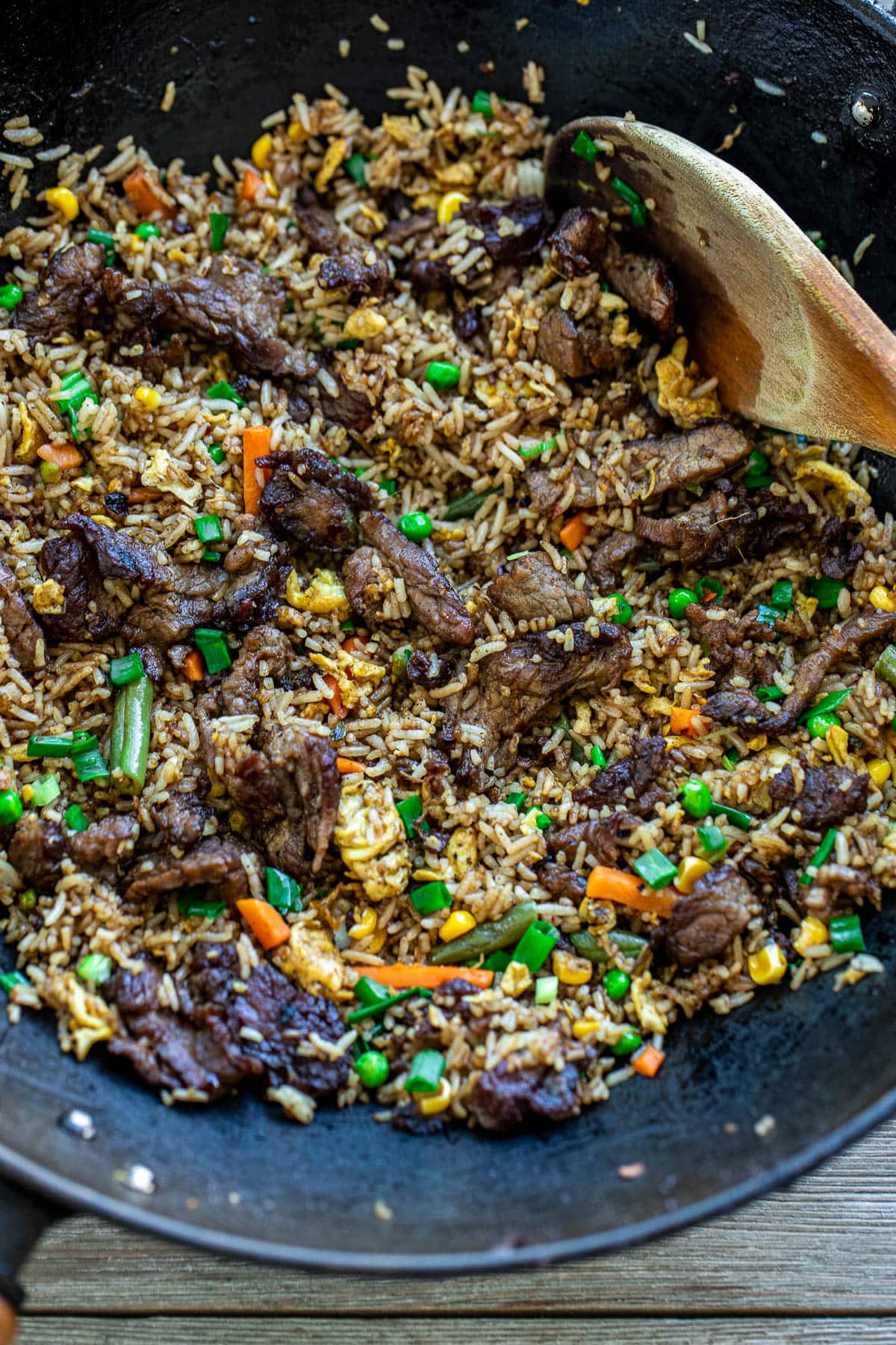 A black wok filled with fried rice.