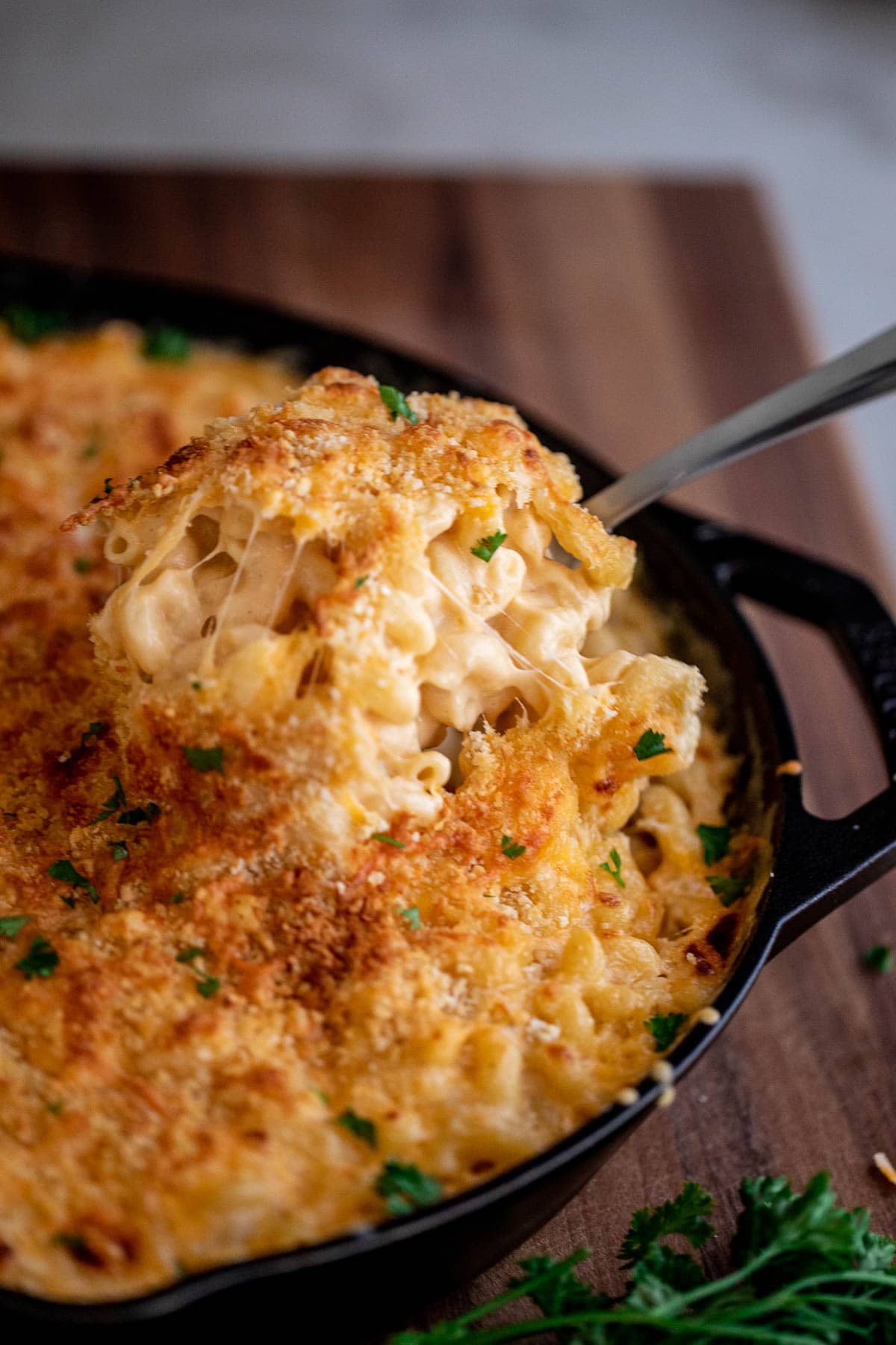 Spoon lifting up creamy mac and cheese from a bowl