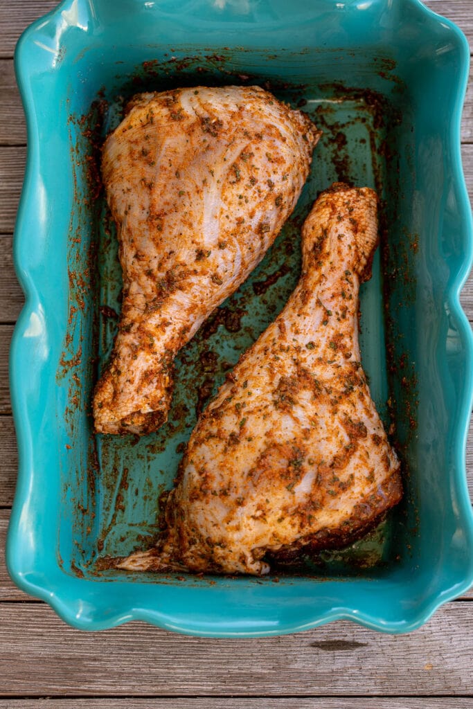 Seasoned turkey drumsticks in a baking dish