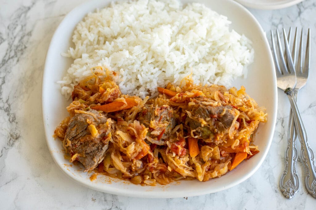 A plate of cabbage and beef stew with rice