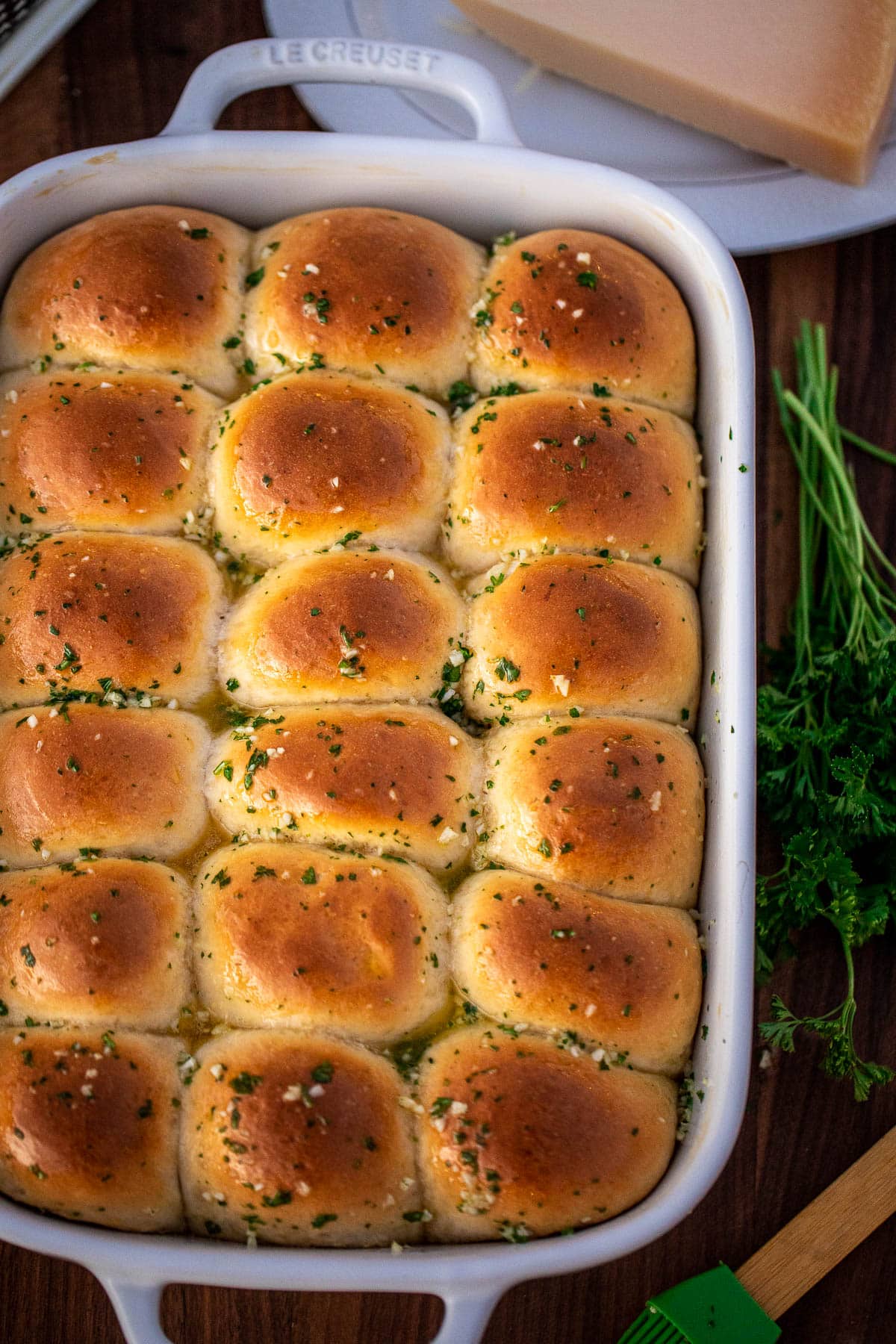 A full baking dish of dinner rolls brushed with garlic butter