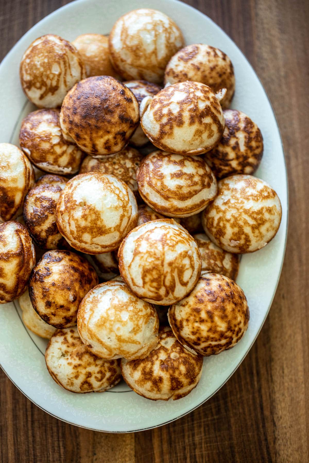 several dozen cooked vitumbua on a white tray.