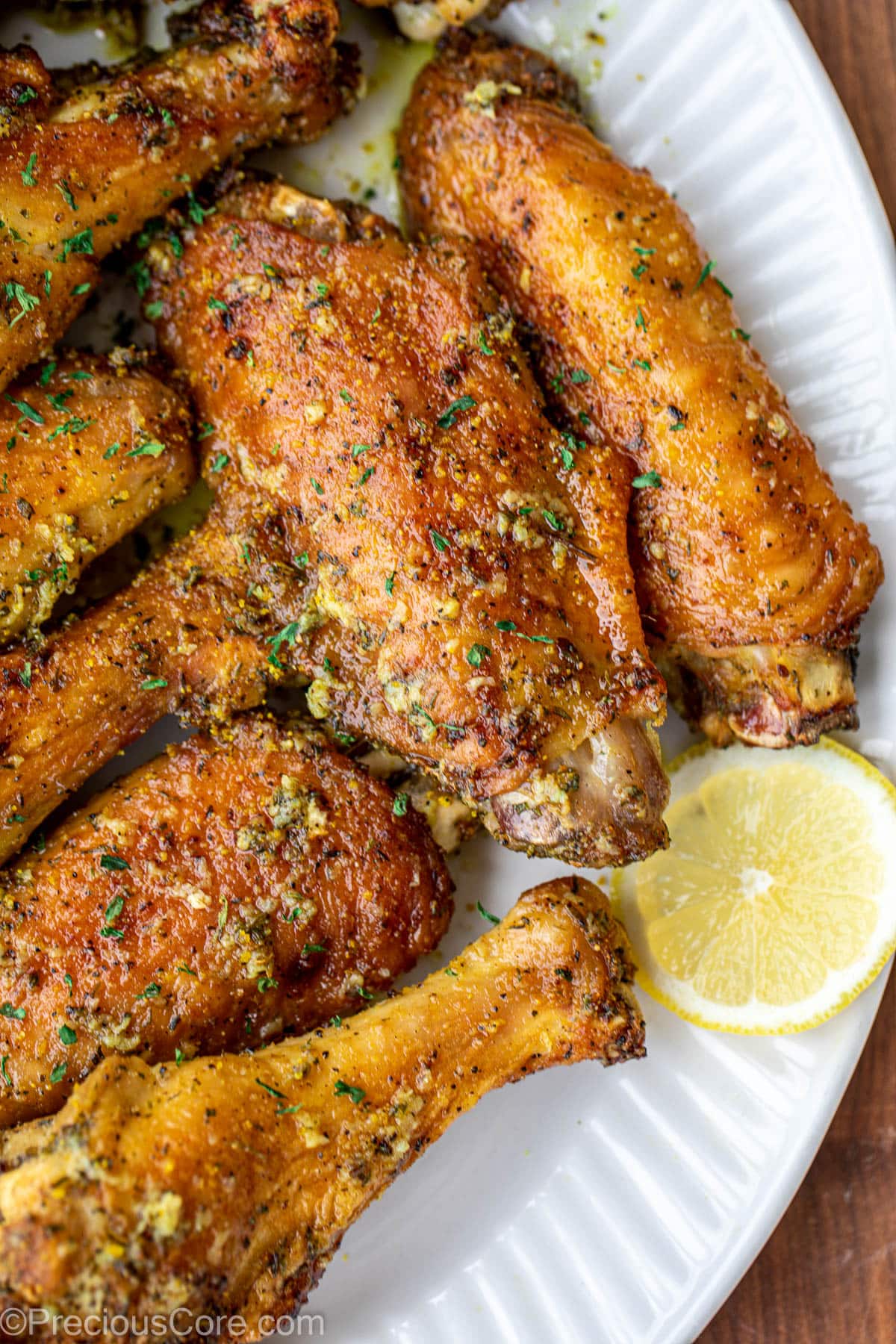 Wings on a serving platter, garnished with a slice of lemon.