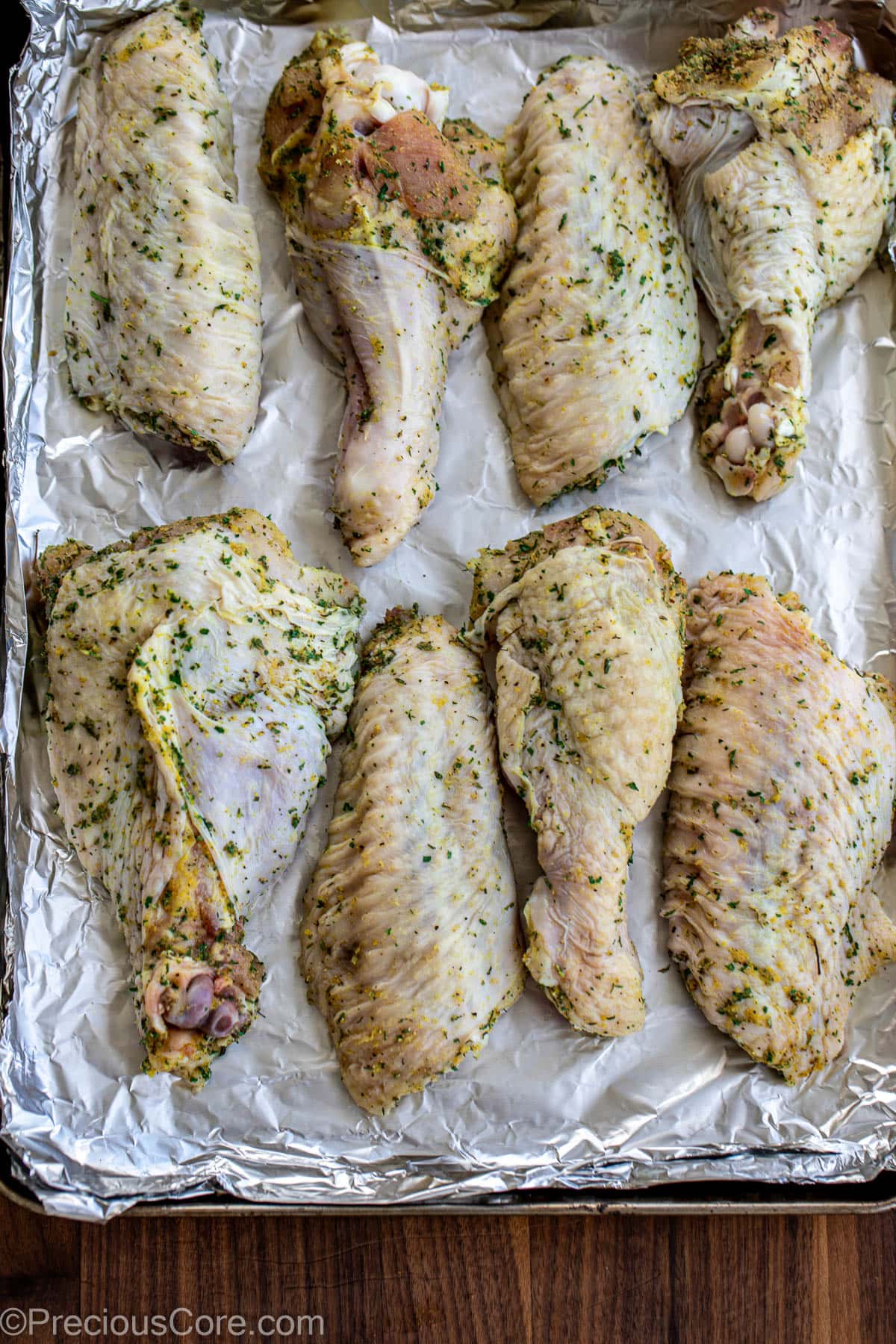 Seasoned turkey wings on a baking sheet.