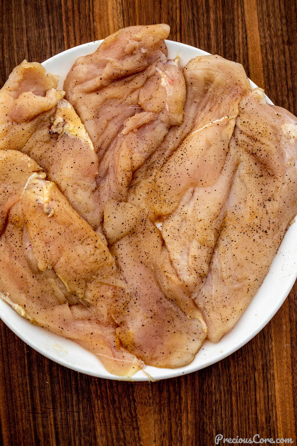 Seasoned chicken breasts on a plate.