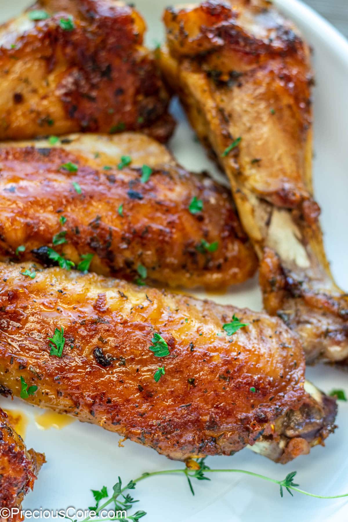 Brown cooked turkey wings garnished with minced parsley.