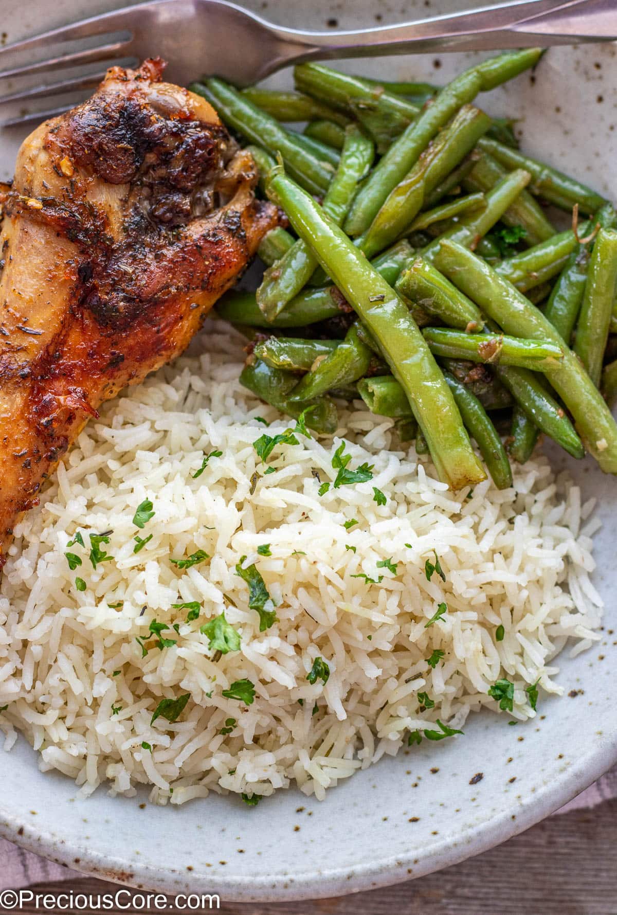 Turkey wing served with garlic herb rice and green beans.