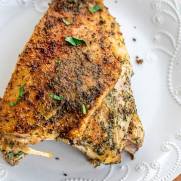 A large roasted turkey thigh on a plate.