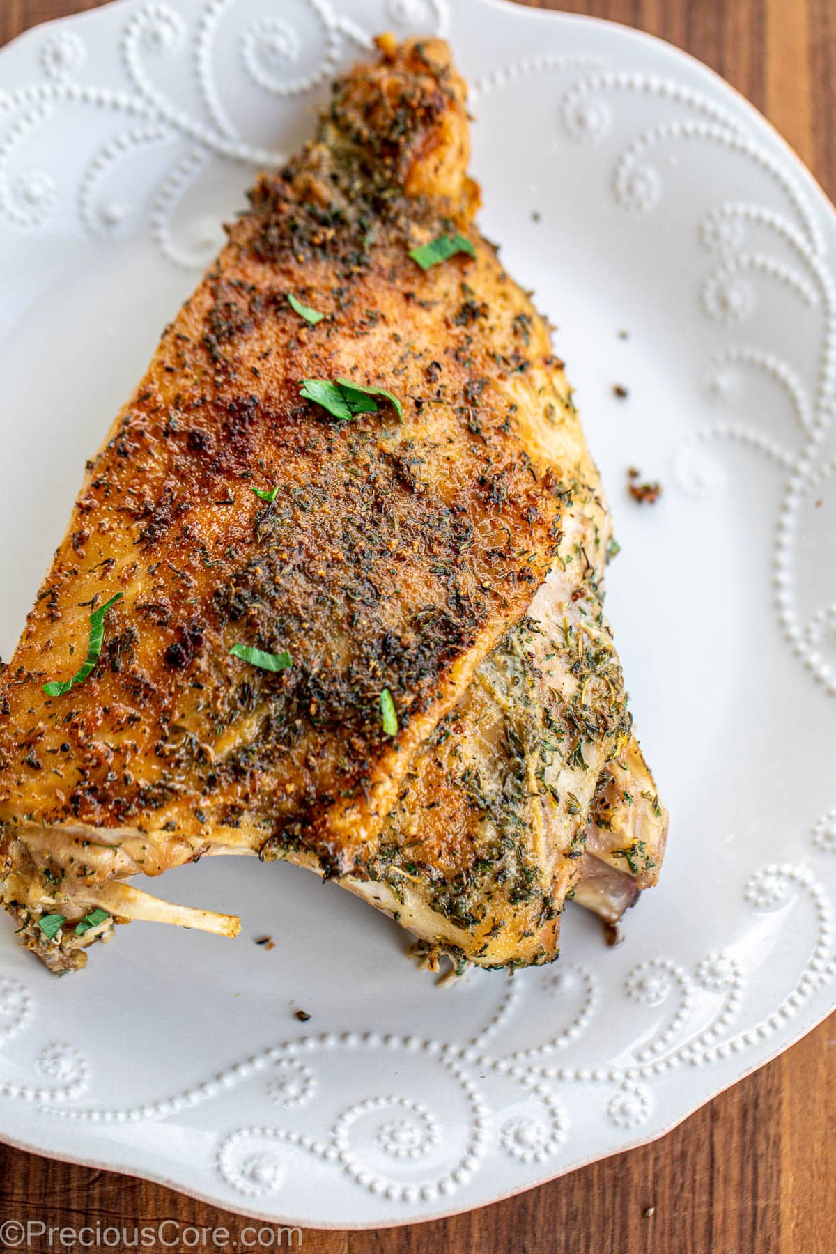 A large roasted turkey thigh on a plate.