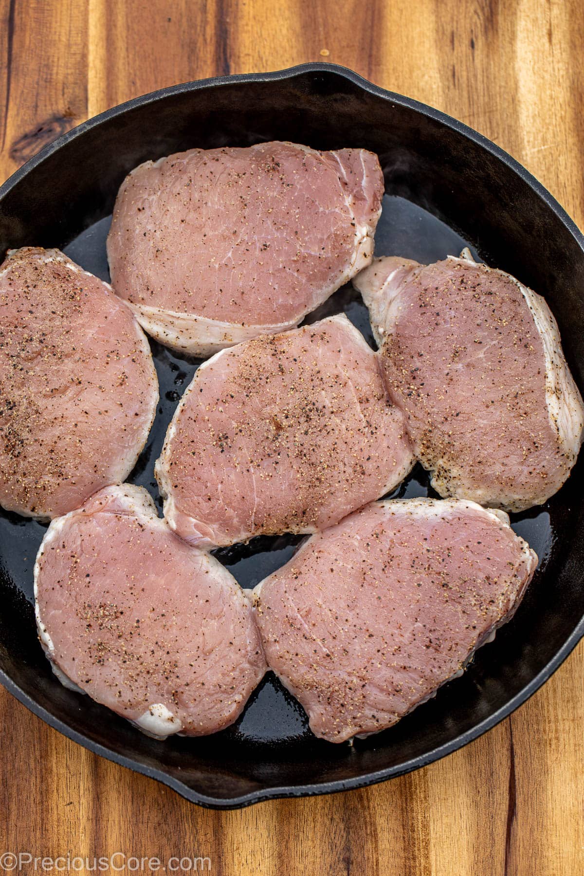 Pork chops in a cast iron skillet.