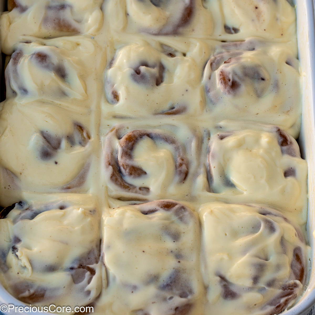 Square image of cinnamon rolls with cream cheese frosting.