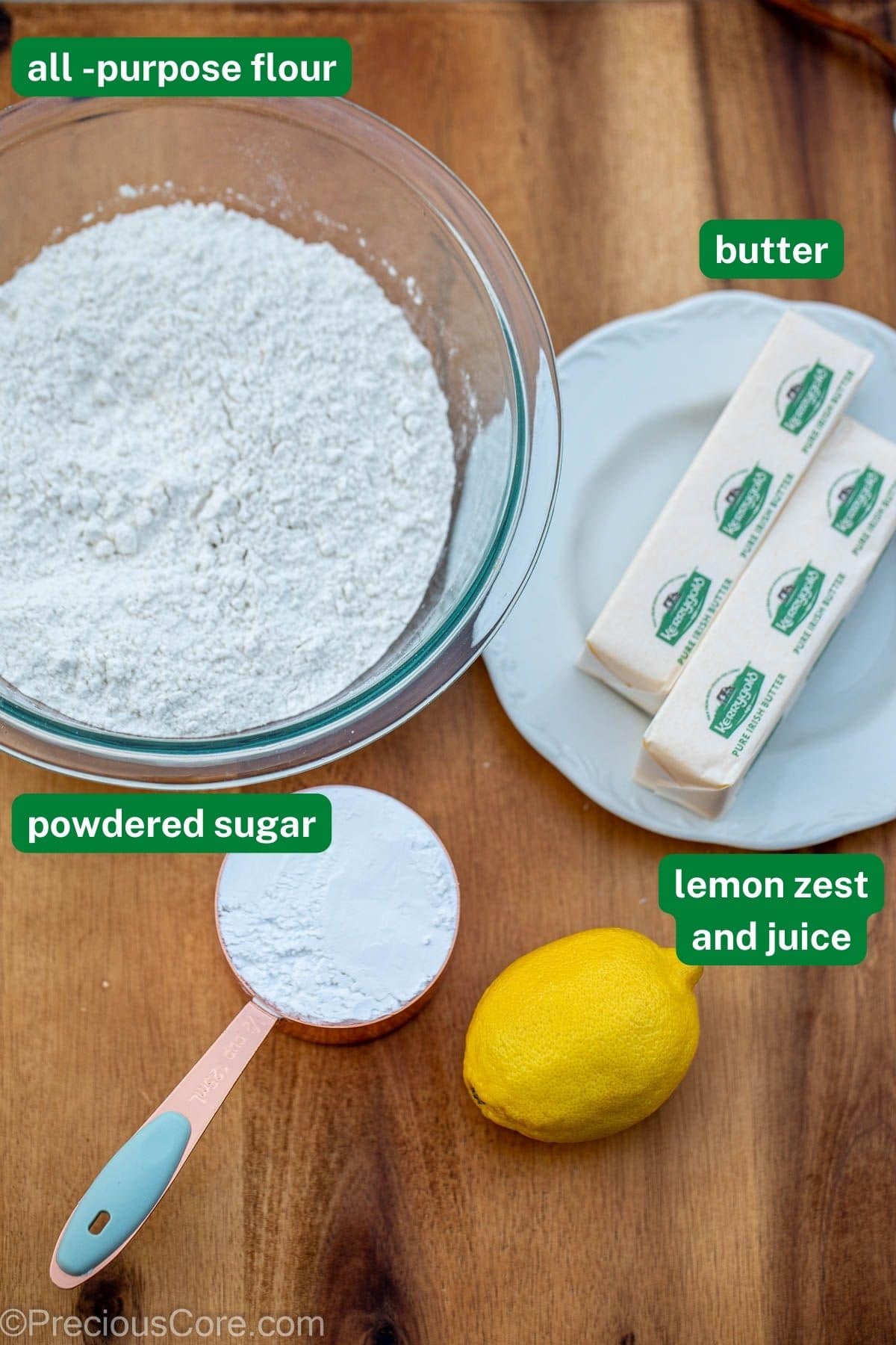 Flour, butter, powdered sugar and lemon on a chopping board.