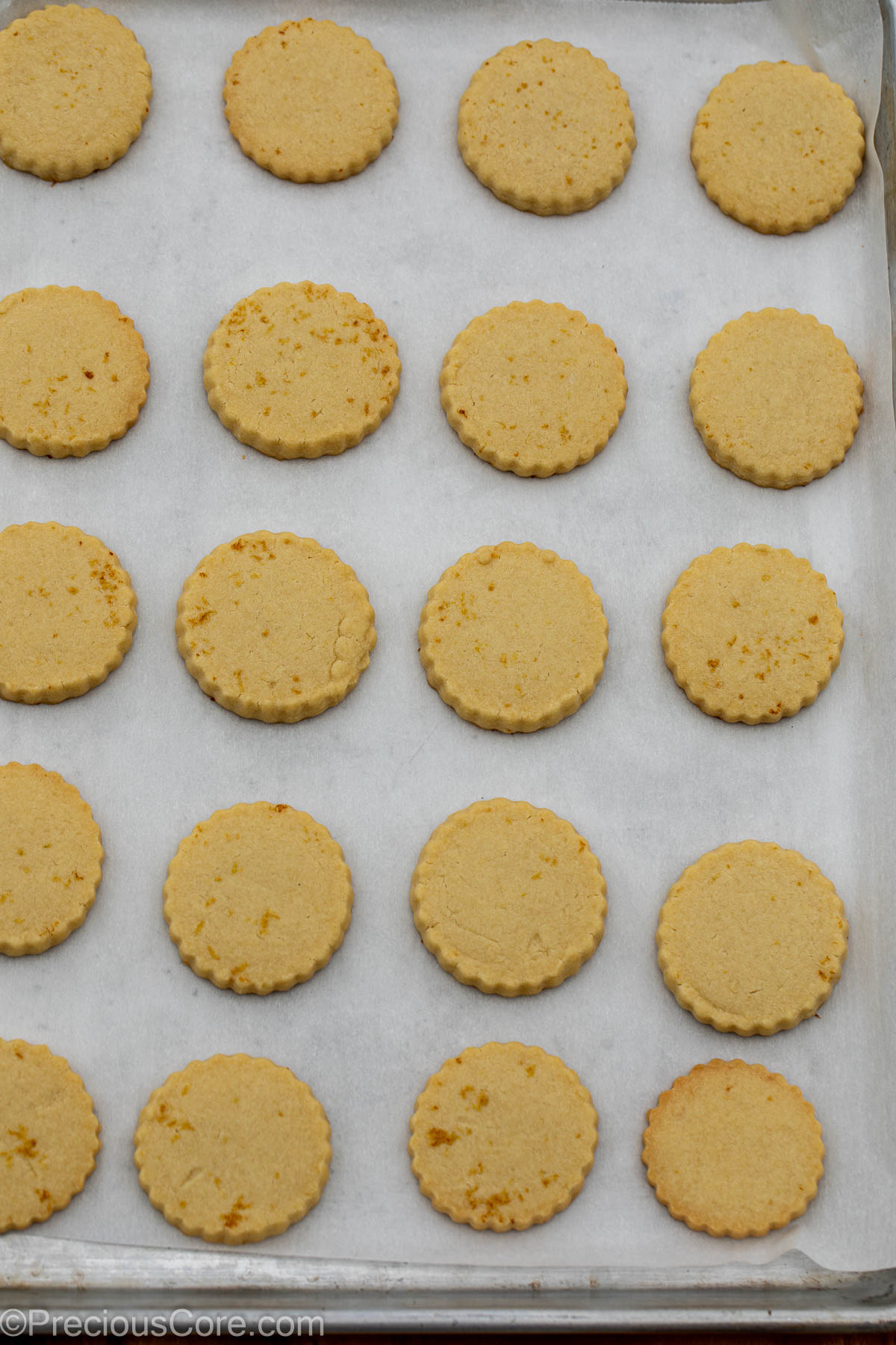 Baked lemon shortbread cookies on baking sheet.