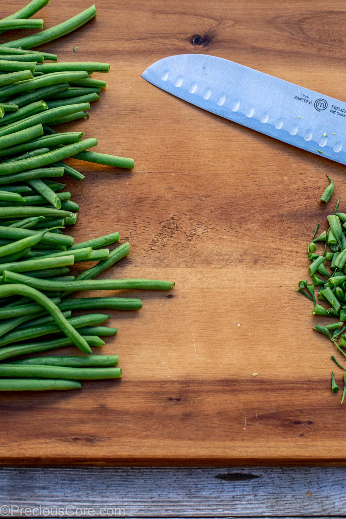 Cutting green beans on chopping board