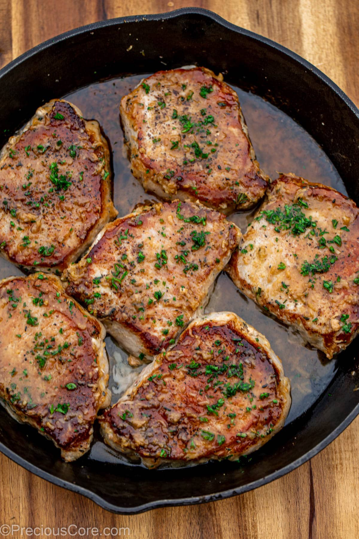 Cooked pork chops in butter sauce.