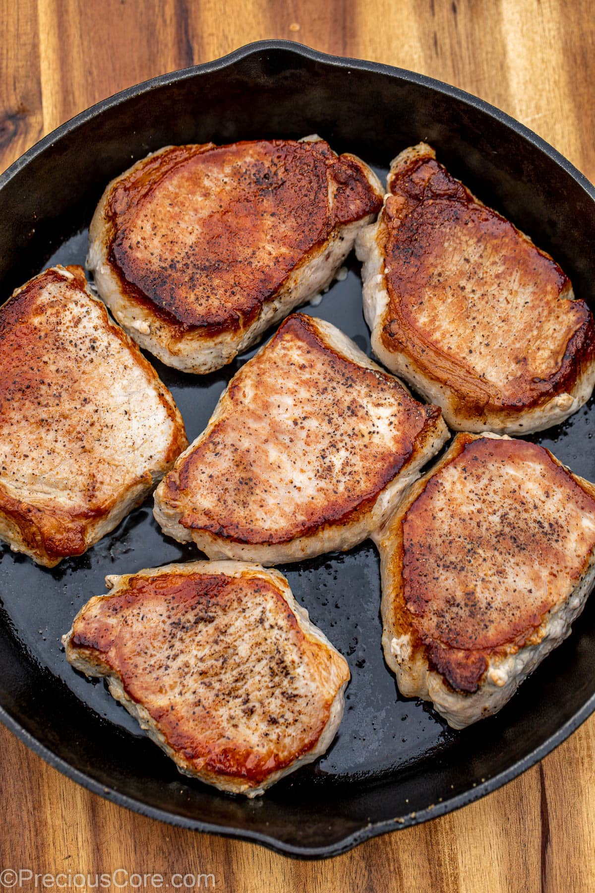 Seared pork chops in a cast iron pan.