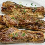 3 baked ribs on a white plate.
