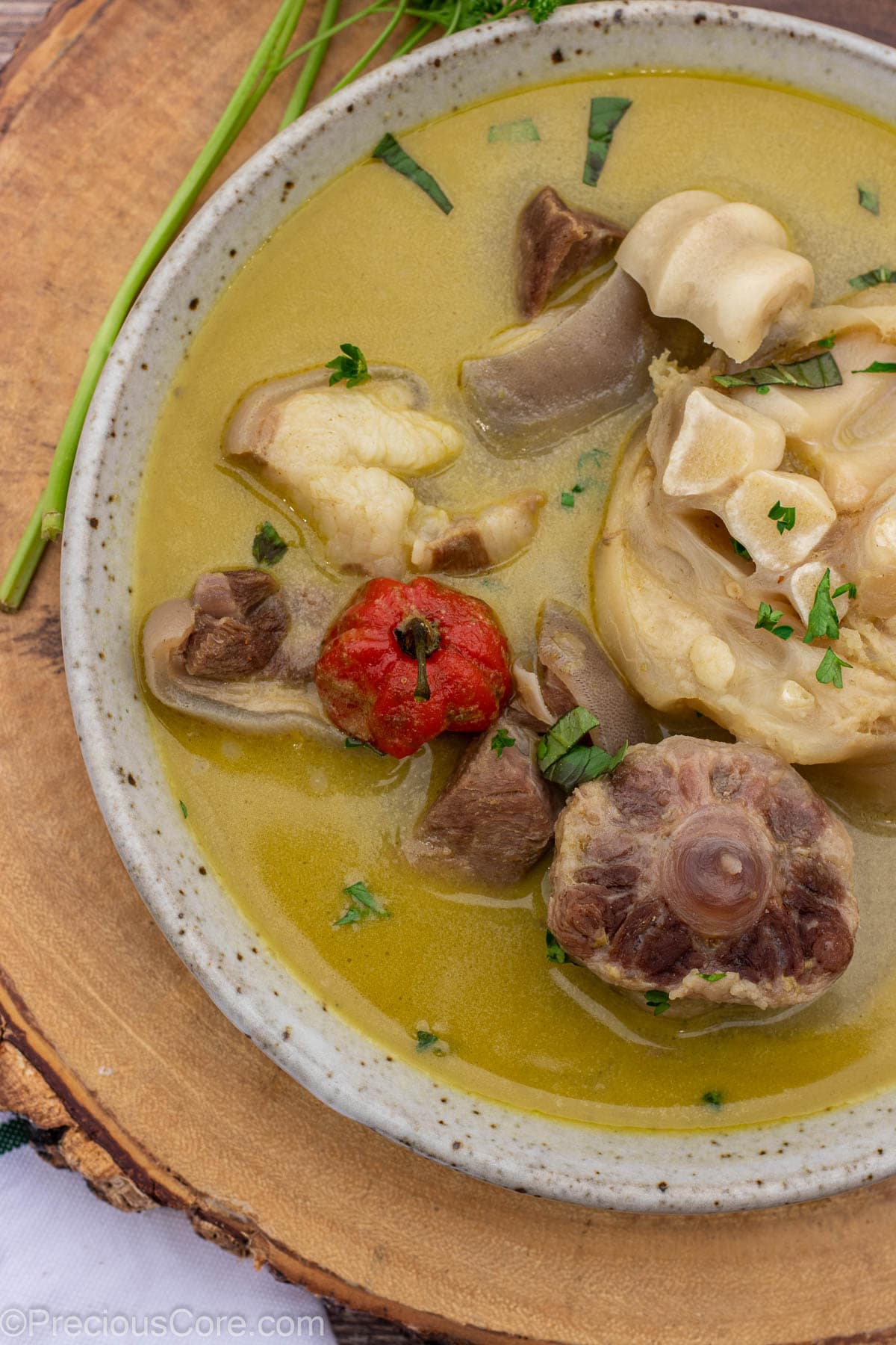 Closer shot of pepper soup with meats in a bowl.