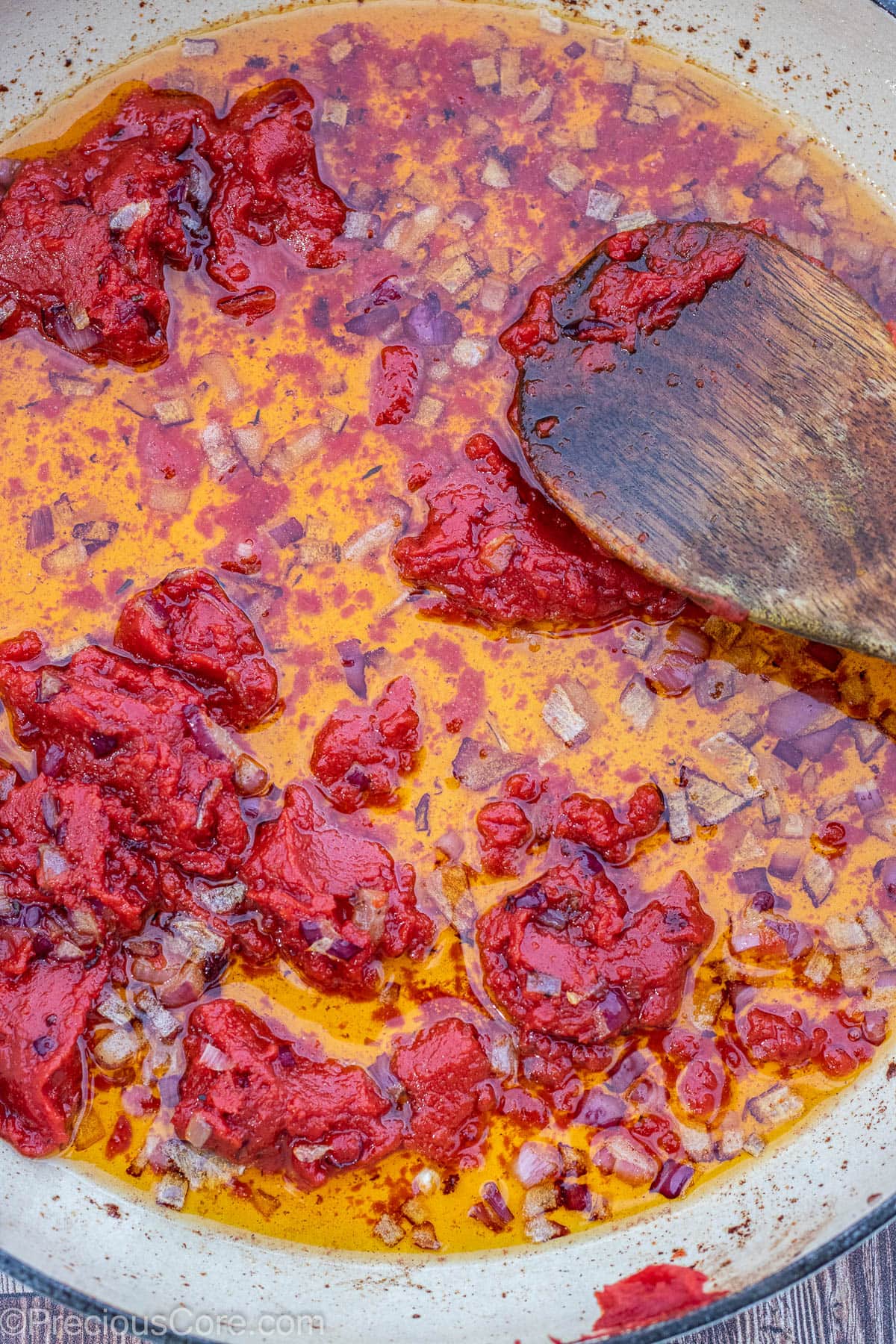 Diced onions and tomato paste cooking in oil.