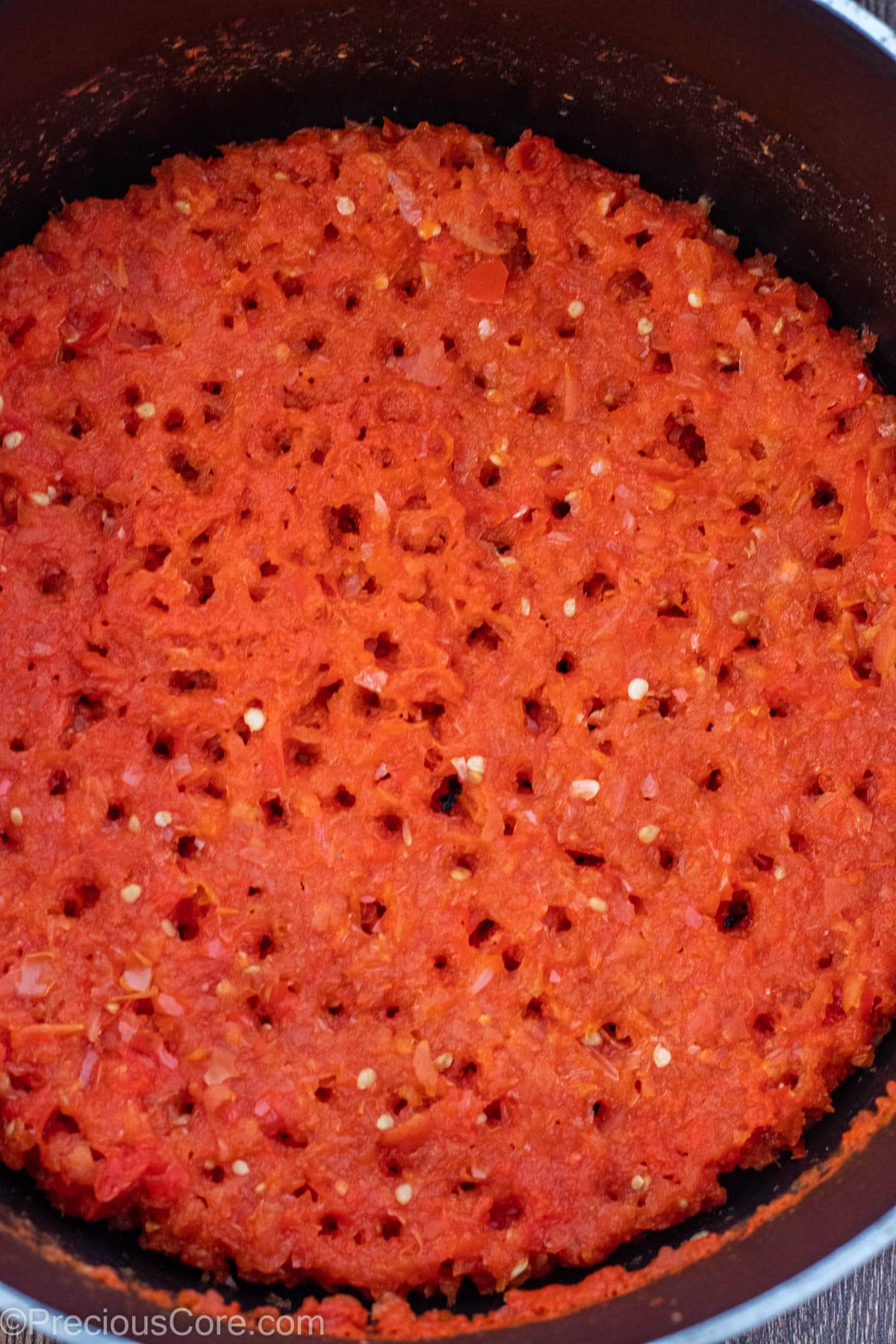 A pot of a tomato-pepper-onion blend that has been cooked down until reduced.
