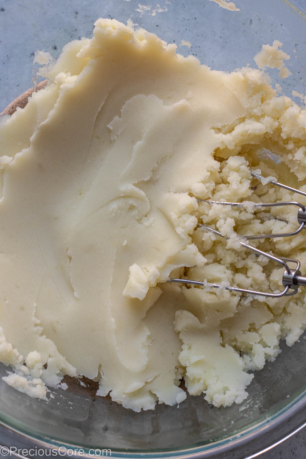 Hand beater in a bowl of mashed potatoes.