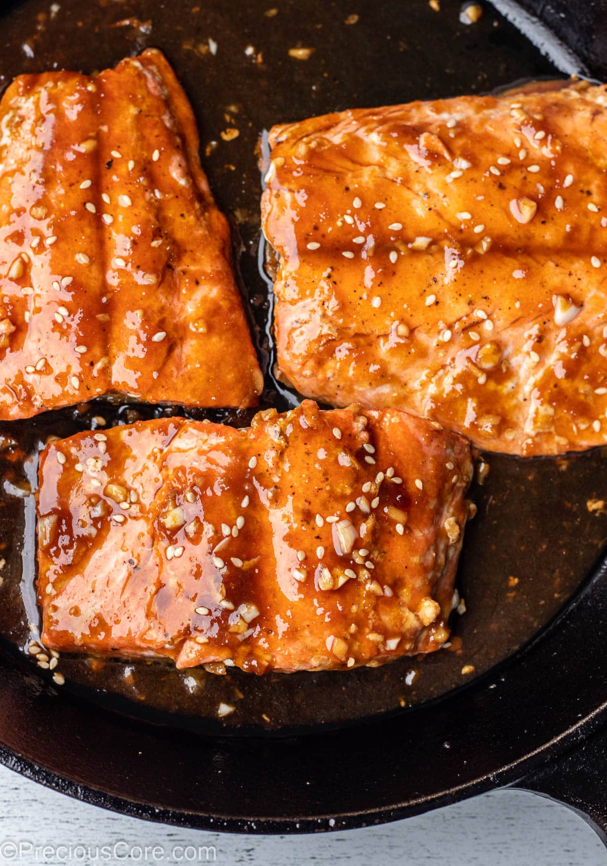 Pan fried teriyaki salmon in cast iron skillet.