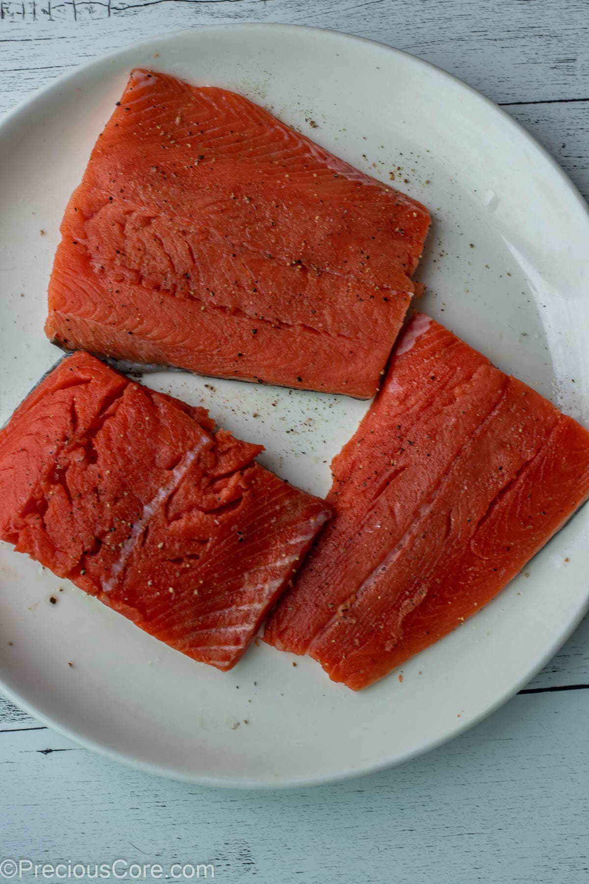 Salmon fillets seasoned with salt and pepper.