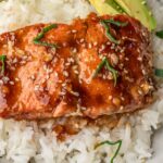 Teriyaki Salmon over rice with avocado slices in a bowl.