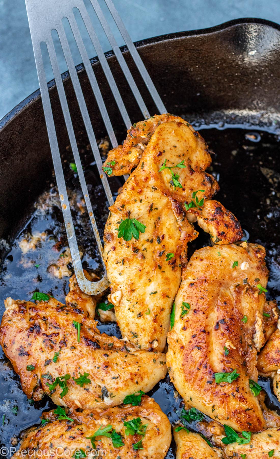 Fish spatula lifting up a pan seared chicken tender.