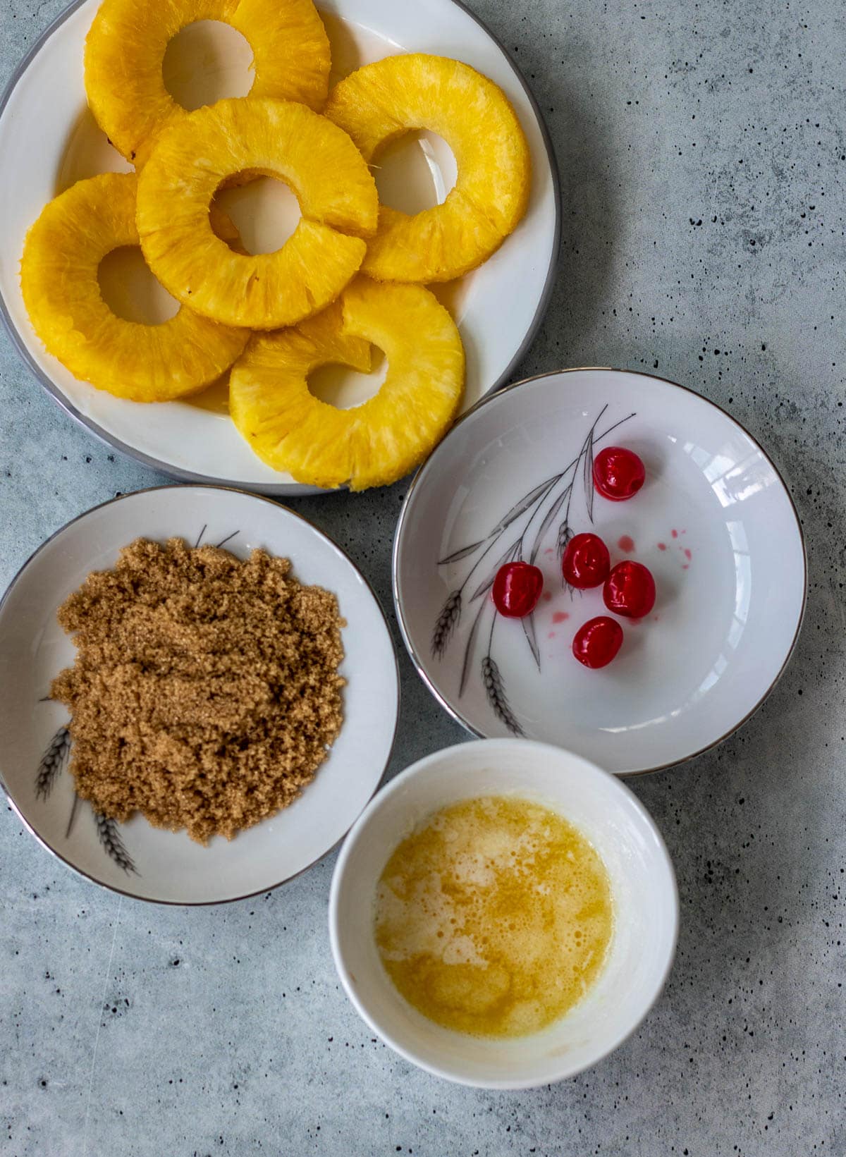 Pineapple rings, maraschino cherries, brown sugar, and melted butter.