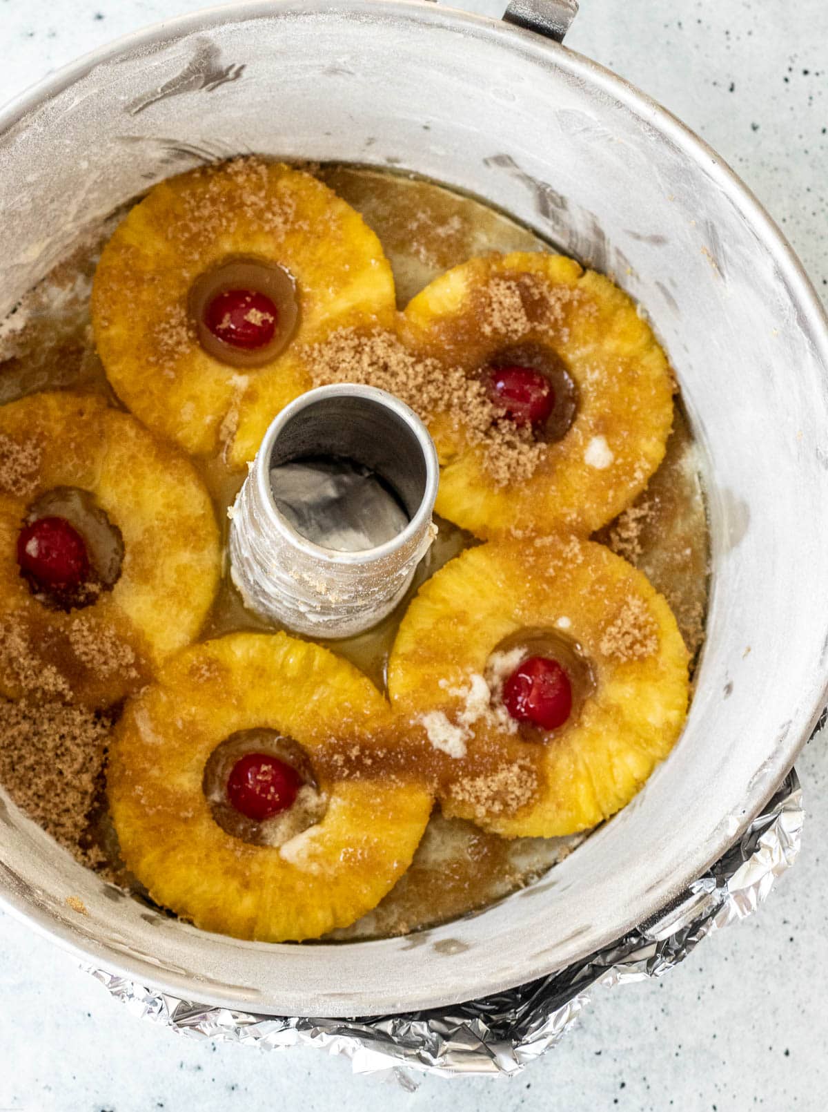 Baking pan covered at the bottom with pineapple rings, maraschino cherries, brown sugar and melted butter.