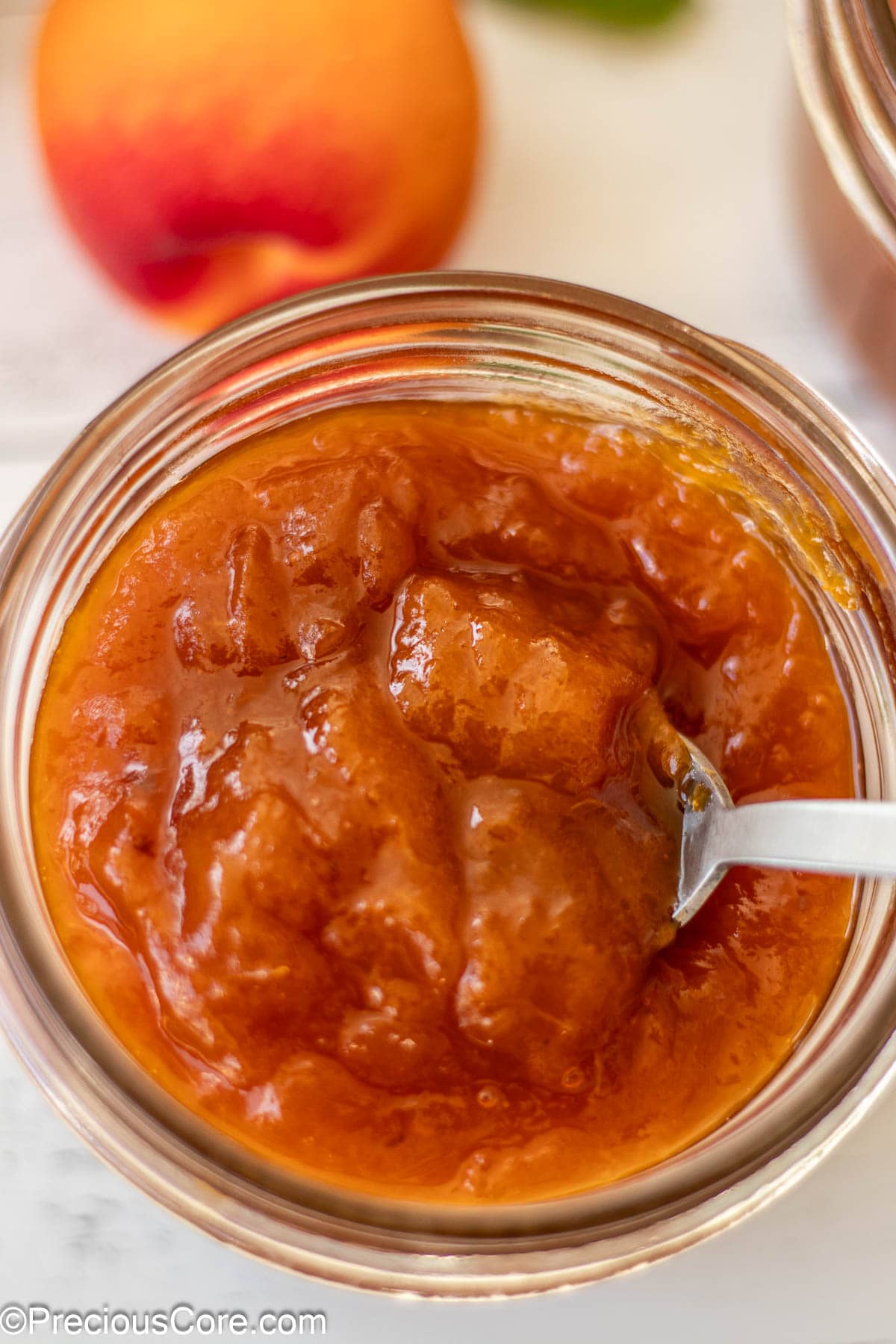 Close-up shot of apricot preserves in a mason jar.