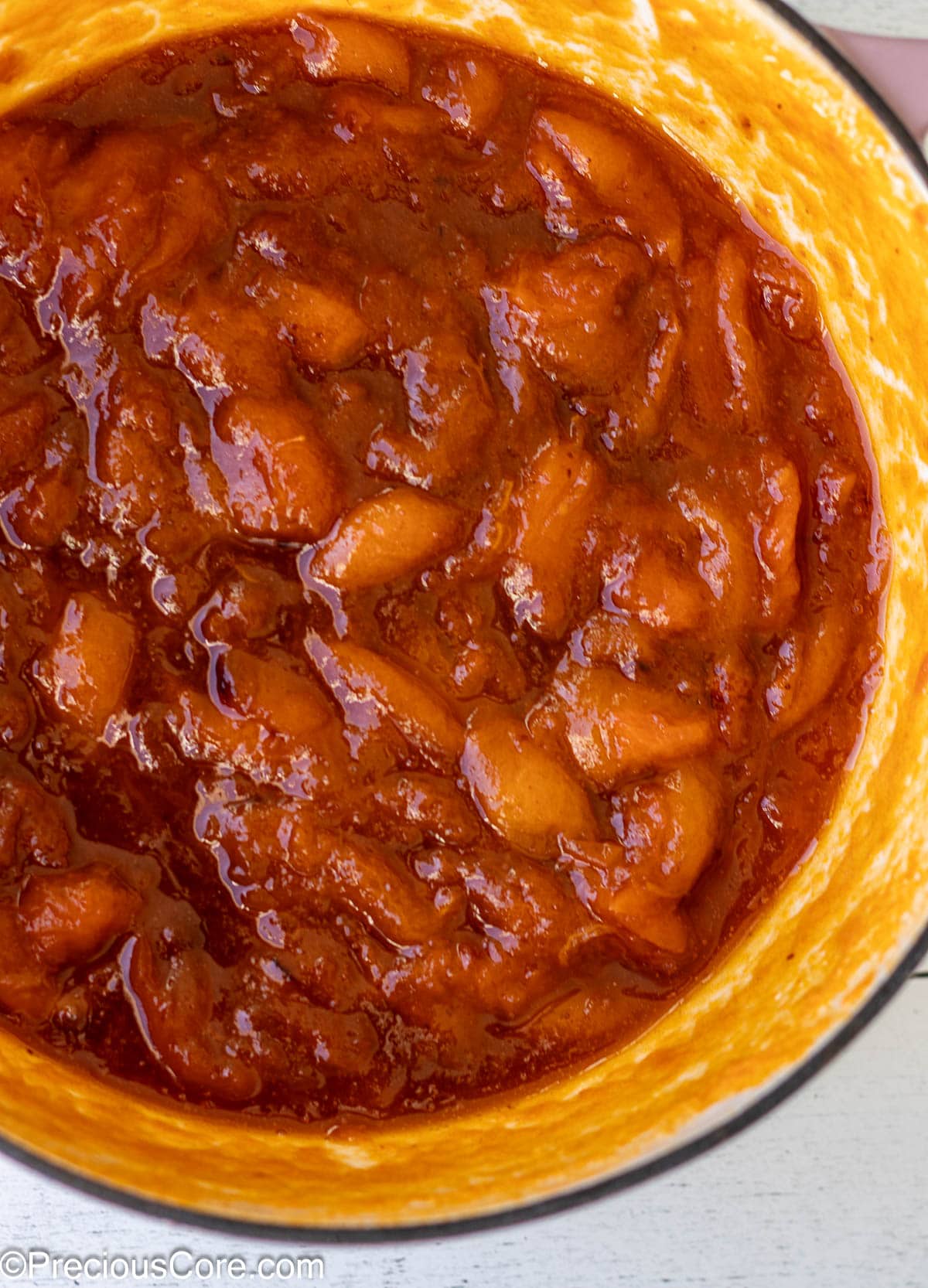 Cooked apricots in an enameled cast iron pot.