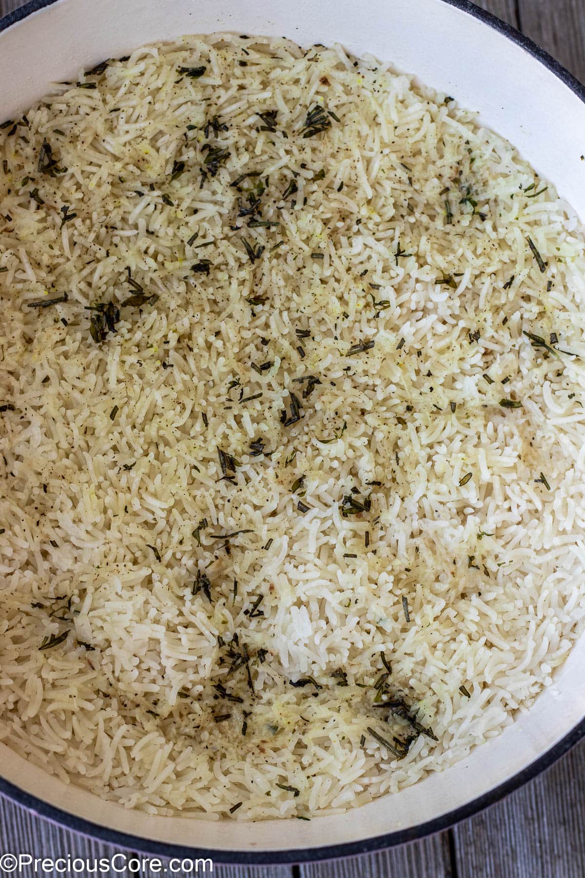 Cooked rice with garlic and herbs in a pot.