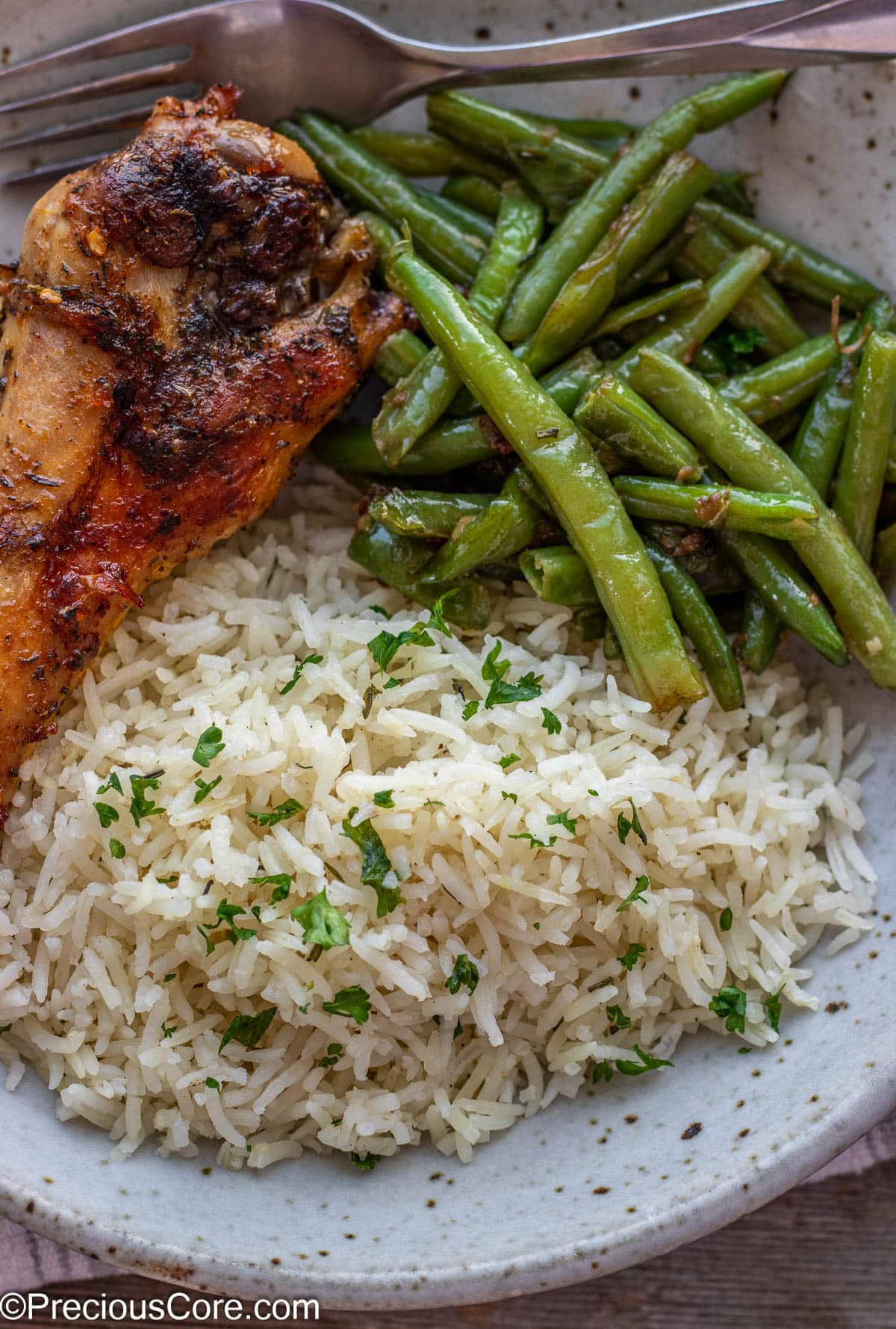A bowl of rice, green beans and turkey.