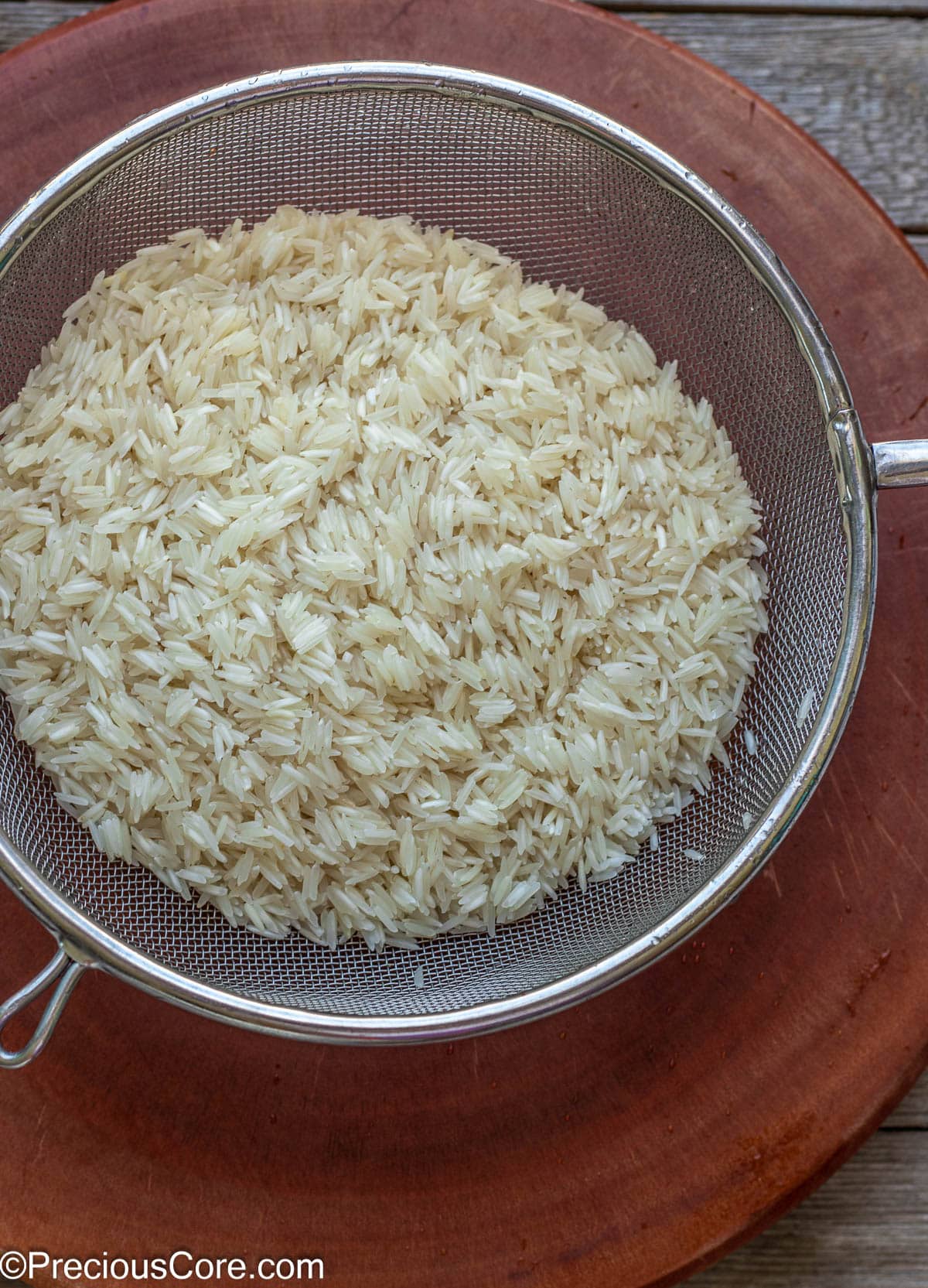 Rinsed rice in a fine mesh strainer.