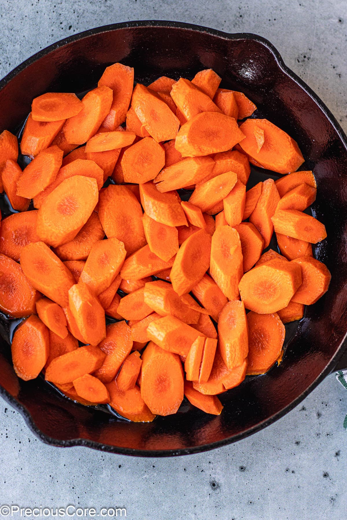 Carrot slices in a cast iron skillet.