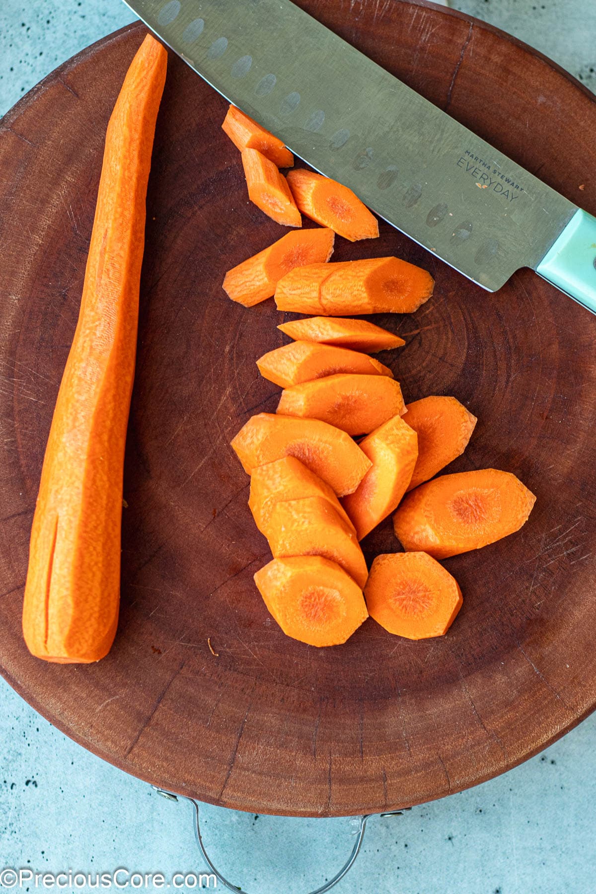 Diagonally cut carrots on a chopping board.