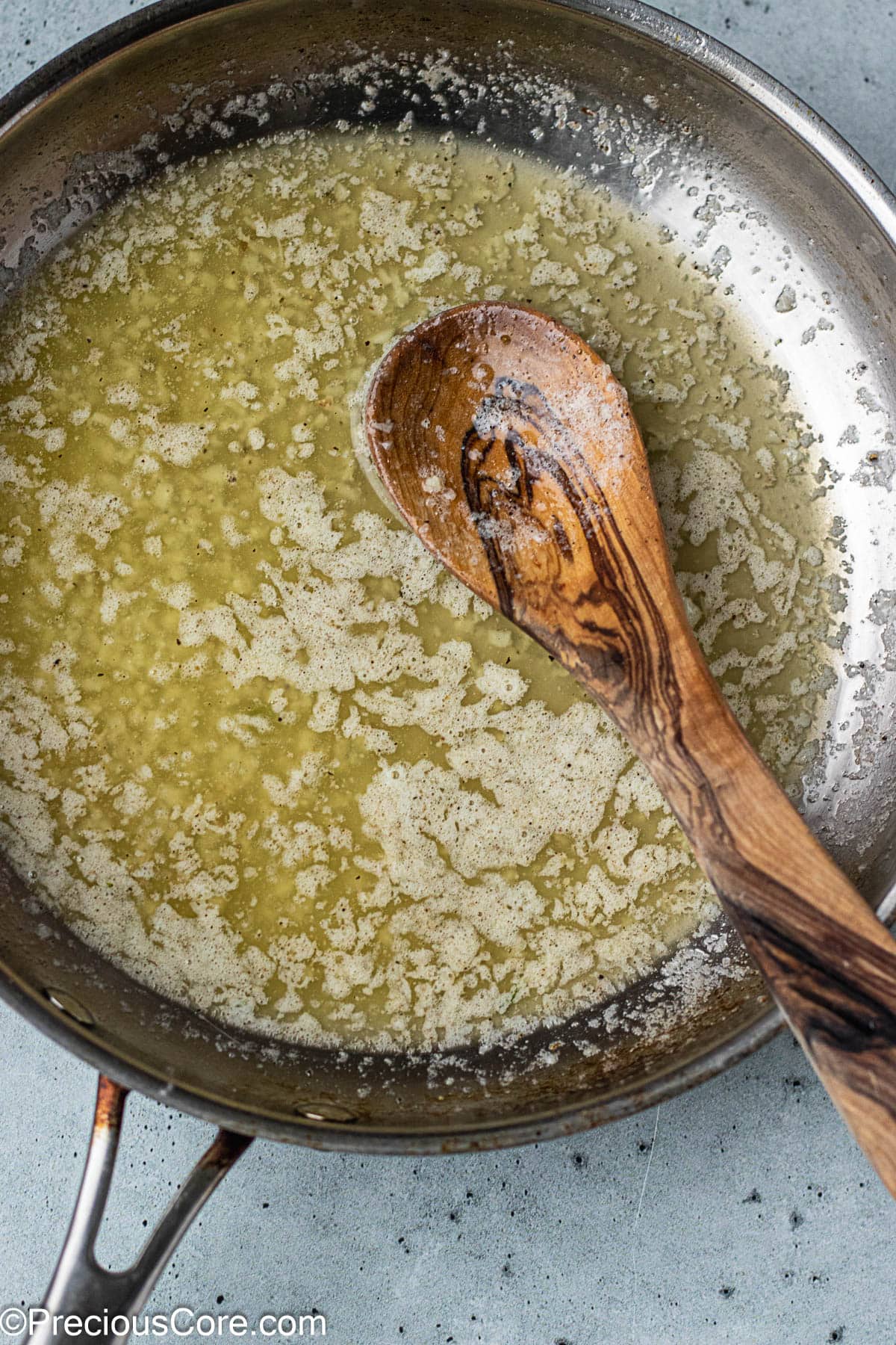 Garlic butter sauce in a stainless steel skillet.