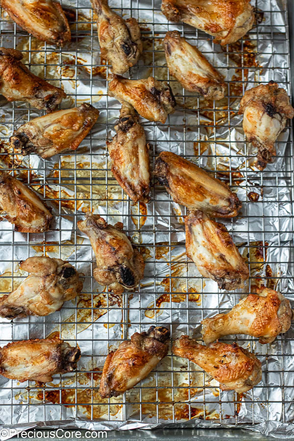 Baked chicken wings on a baking rack.